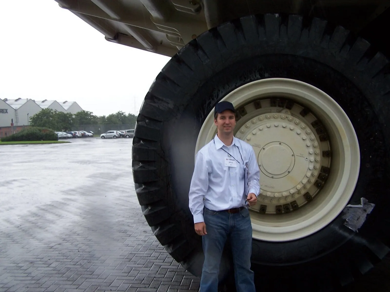 Chris standing beside a haul-truck tire taller than he is