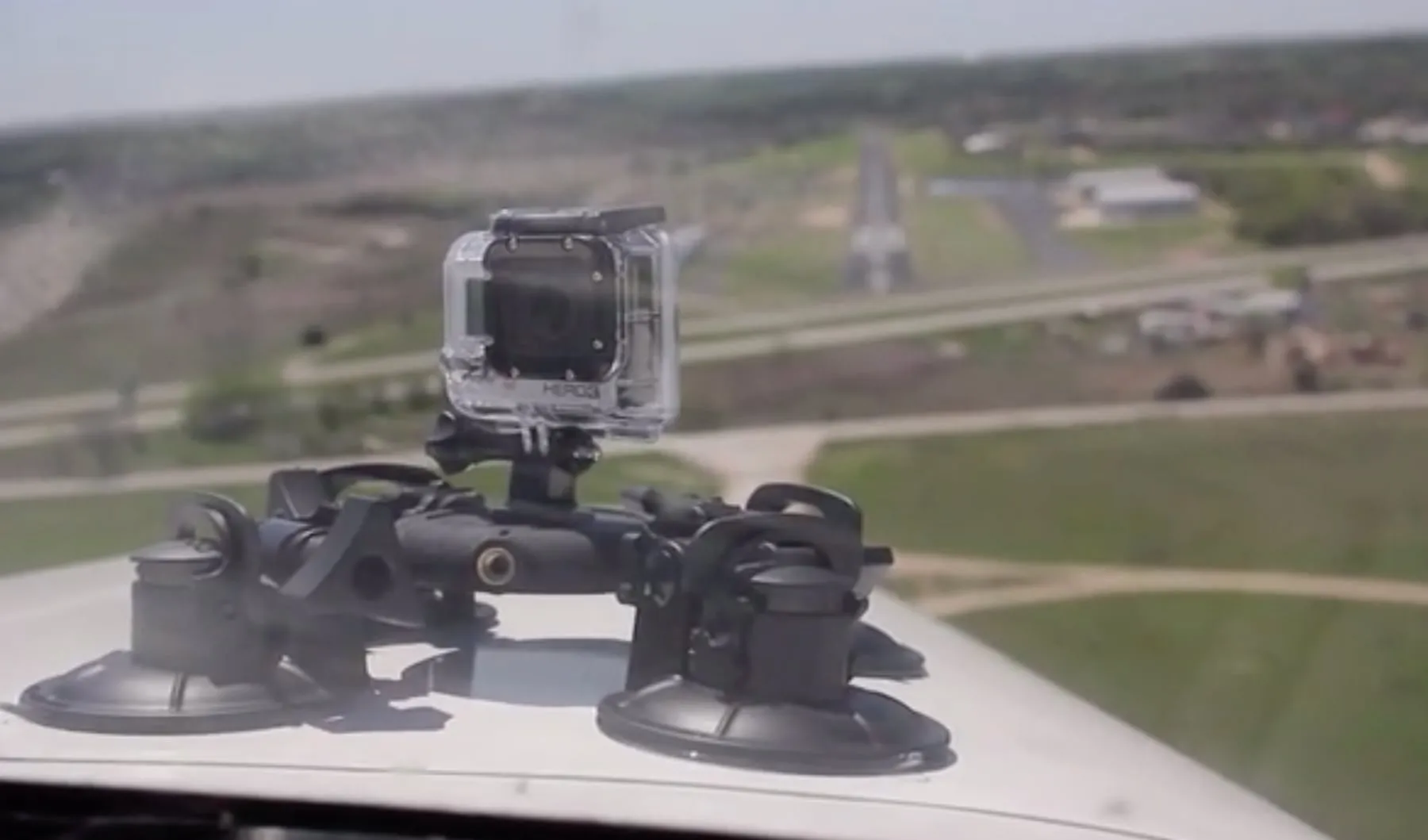 A GoPro on a Tooga suction mount on an airplane, a runway ahead